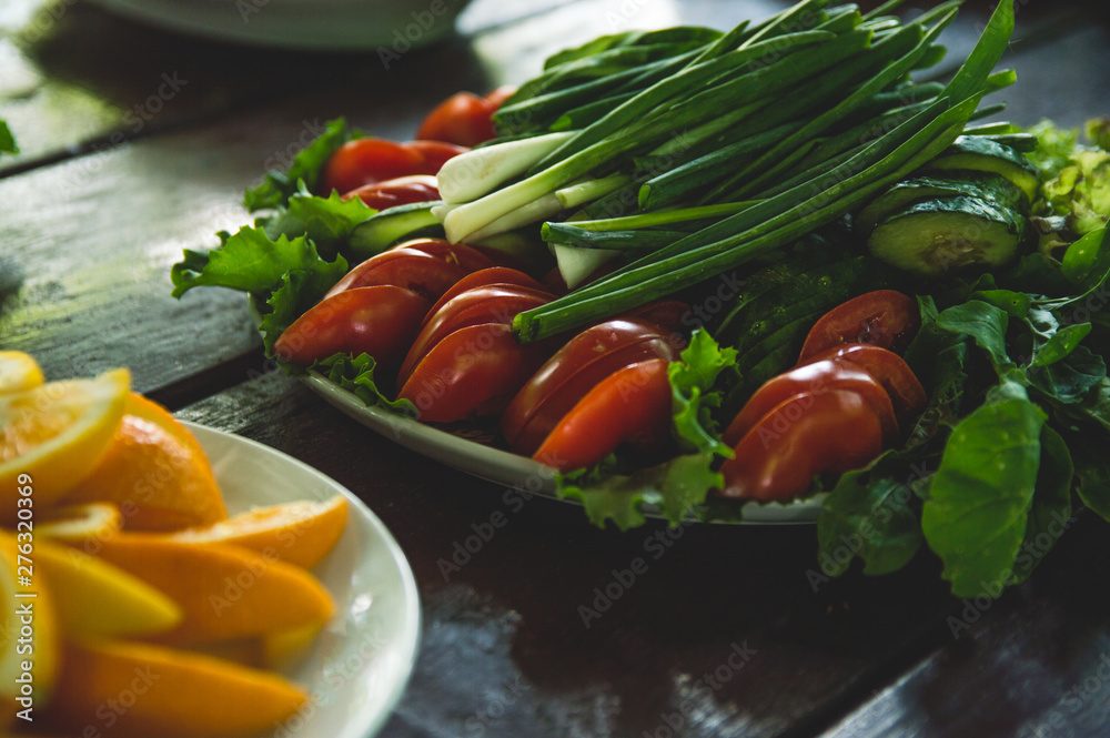 Vegetables and fruits are sliced on a wooden table. Picnic in the summer. Fresh vegetables. Party in nature. Vegetables and fruits are sliced on a wooden table. Picnic in the summer. Fresh vegetables. Party in nature.