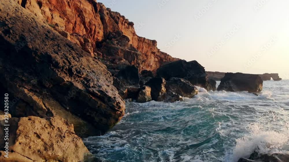 Sea beating against rocks on a sunset background. Sea beating against rocks on a sunset background.