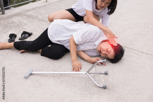 Vászonkép Senior asian woman faint lying down and unconscious outdoor,Daughter take care a