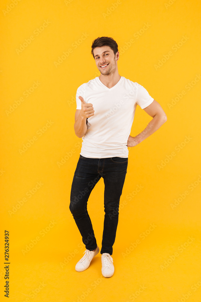 Full length photo of masculine man in basic t-shirt smiling and showing thumb up