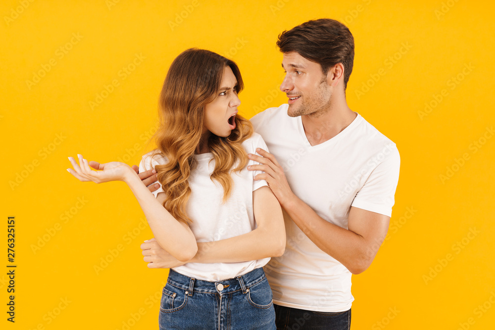 Portrait of caucasian man asking for forgiveness stressed woman after fight standing with arms crossed Portrait of caucasian man asking for forgiveness stressed woman after fight standing with arms crossed