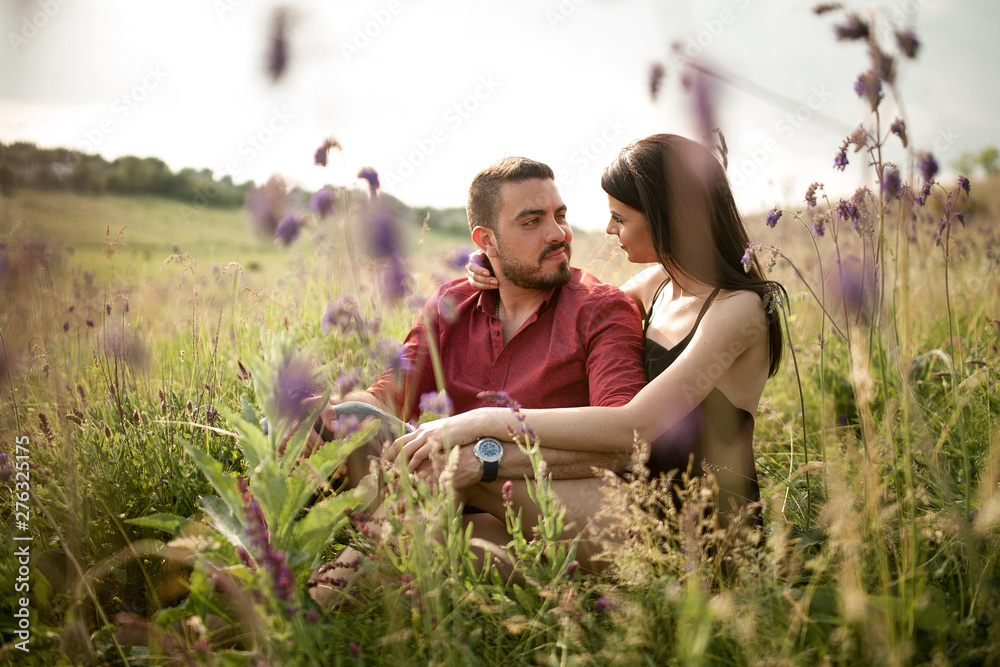 A young couple is resting in a meadow. A young couple is resting in a meadow.