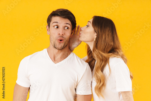 Fotografie Portrait of joyful woman whispering secret or interesting gossip to excited man