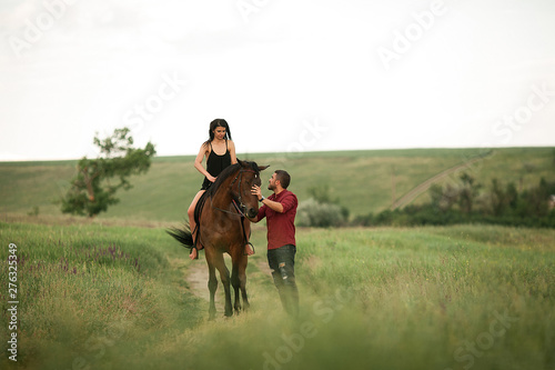 A young couple walks during horseback riding.