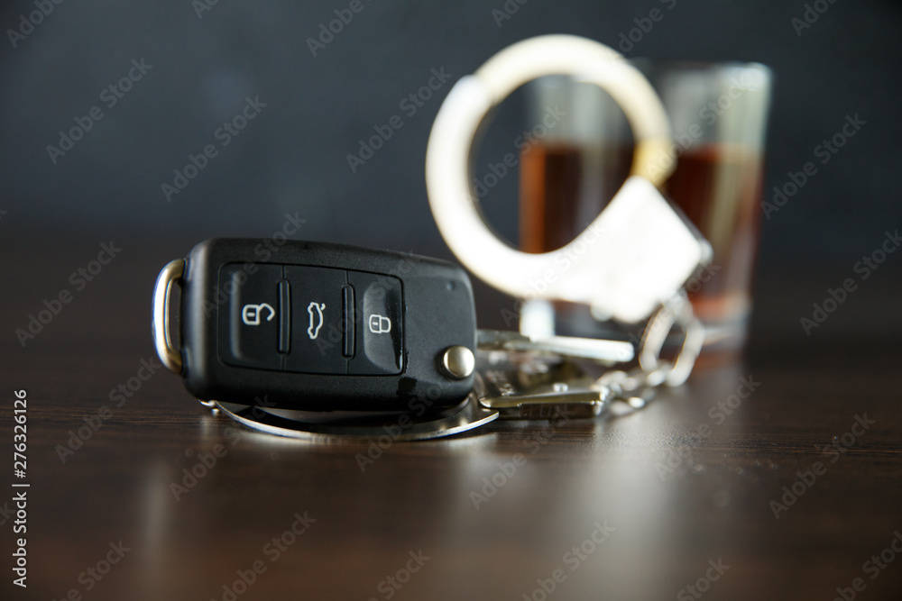 The concept of a DUI. Law hammer, alcohol and car keys on wooden table, dark background The concept of a DUI. Law hammer, alcohol and car keys on wooden table, dark background