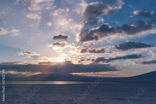 Sunrise in the mountains on the lake Son-Kul against cloud sky photo