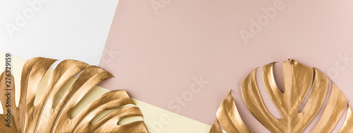 Top view of gold tropical palm Monstera leaf on pink background. Flat lay, vi...