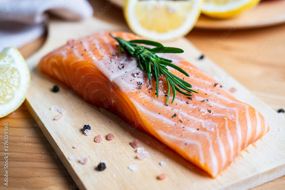 Fresh salmon steak with herbs, lemon and ingredients for cooking in kitchen Fresh salmon steak with herbs, lemon and ingredients for cooking in kitchen