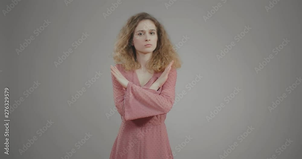 Caucasian girl rejects proposal with gesture. She crosses hands and shakes head Caucasian girl rejects proposal with gesture. She crosses hands and shakes head