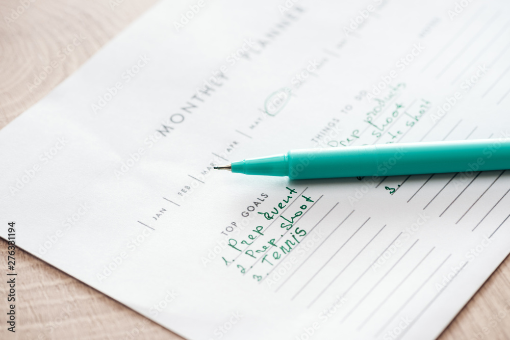 selective focus of monthly planner with green pen selective focus of monthly planner with green pen