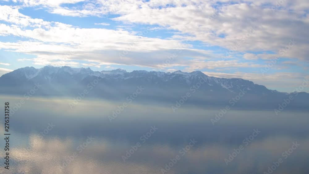 Aerial drone static shot of a lake covered with mist and fog surrounded by snow covered mountains and villages in Mont Blanc, France Aerial drone static shot of a lake covered with mist and fog surrounded by snow covered mountains and villages in Mont Blanc, France
