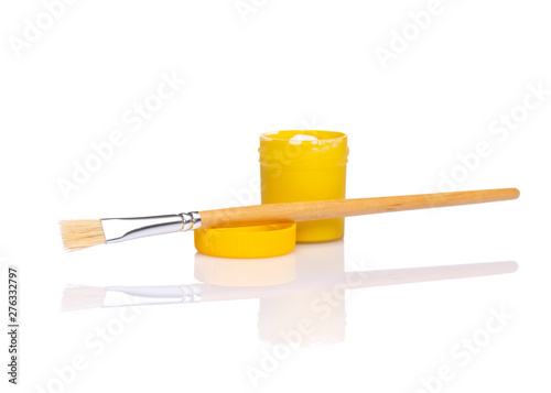 Opened yellow Gouache jar with wooden artist painting brush, isolated on white background with copy space. Cans of different colors gouache paints.