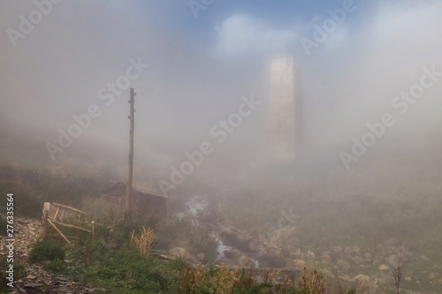 Svan tower at high mountain village Adishi in haze soft light at small mountain spring