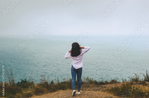 young casual woman travel  in white t shirt and jeans   posing near sea © Mariana