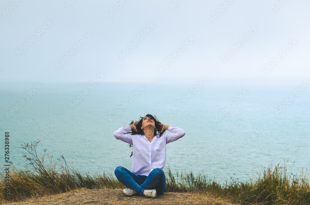 Fototapeta premium young casual woman travel in white t shirt and jeans posing near sea