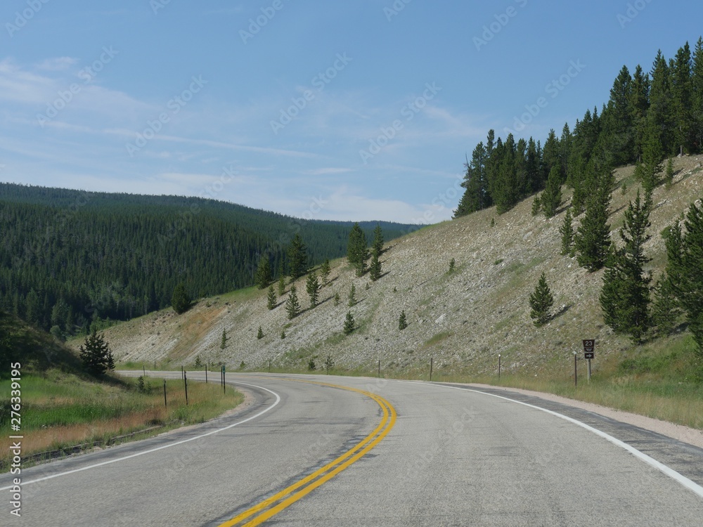 Winding road along rolling hills at the Bighorn mountains in Wyoming.