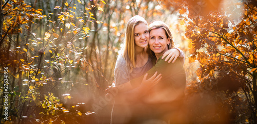 Mother and daughter in beautifiul autumn forest