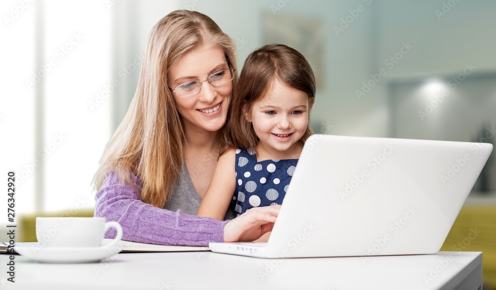 Happy mother with dauther using laptop at home Happy mother with dauther using laptop at home