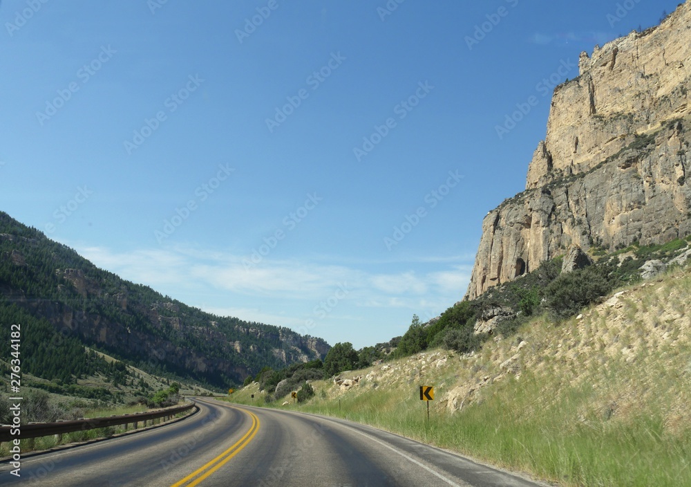 Wide view of scenic a road along high rock walls through the Bighorn Mountains in Wyoming.