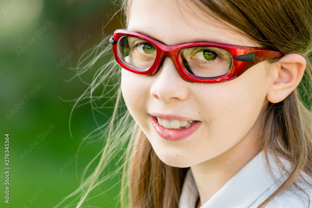 Fotka „Close-up portrait of a girl child wearing red prescription sports  glasses or goggles“ ze služby Stock | Adobe Stock