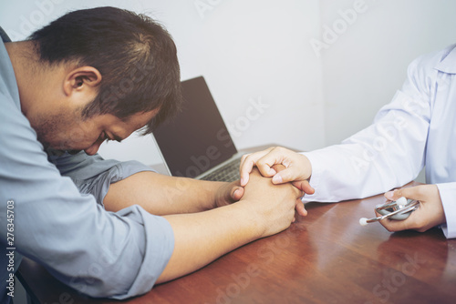 Female psychiatrist touching on stress patient man hands to cheer up him from sadness in clinic hospital health ideas concept