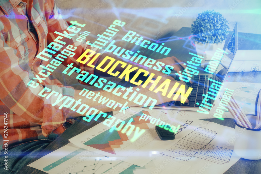 Crypto currency theme hologram with businessman working on computer on background. Concept of blockchain. Multi exposure.