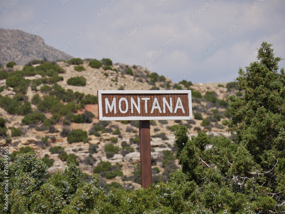 Wide shot of Montana sign by the roadside at the Montana-Wyoming boundary at Bighorn Wide shot of Montana sign by the roadside at the Montana-Wyoming boundary at Bighorn