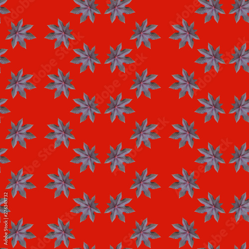 Seamless repeating pattern from ricinus communis on red background photo