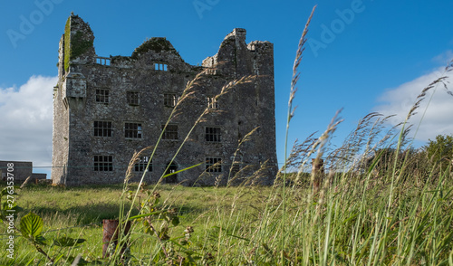 A portrait view of a huge magnificent looking ruins of an Irish Castle in County Ennis, Ireland. photo