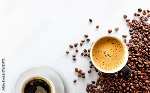 gorące espresso i ziarna kawy na białym stole z delikatnym ustawieniem ostrości i światłem w tle. widok z góry