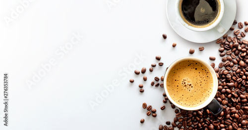 gorące espresso i ziarna kawy na białym stole z delikatnym ustawieniem ostrości i światłem w tle. widok z góry