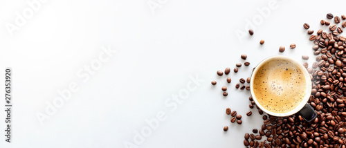 gorące espresso i ziaren kawy na białym stole z nieostrość i światło w tle. widok z góry