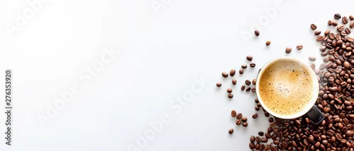 Obraz gorące espresso i ziarna kawy na białym stole z miękkim ogniskiem i światłem w tle. widok z góry
