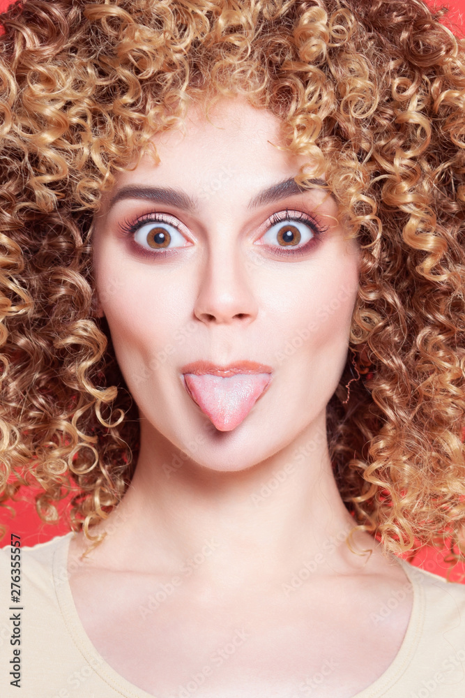 Fototapeta premium Beautiful young cheerful girl with shows tongue