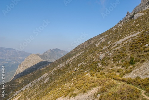 Moutains of the Sierra Bernia, group of tiny, distant, hikers on walking trail, Alicante Province, Spain