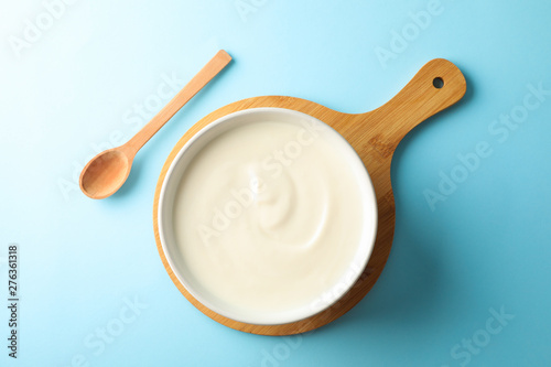 Composition with yogurt in bowl on color background