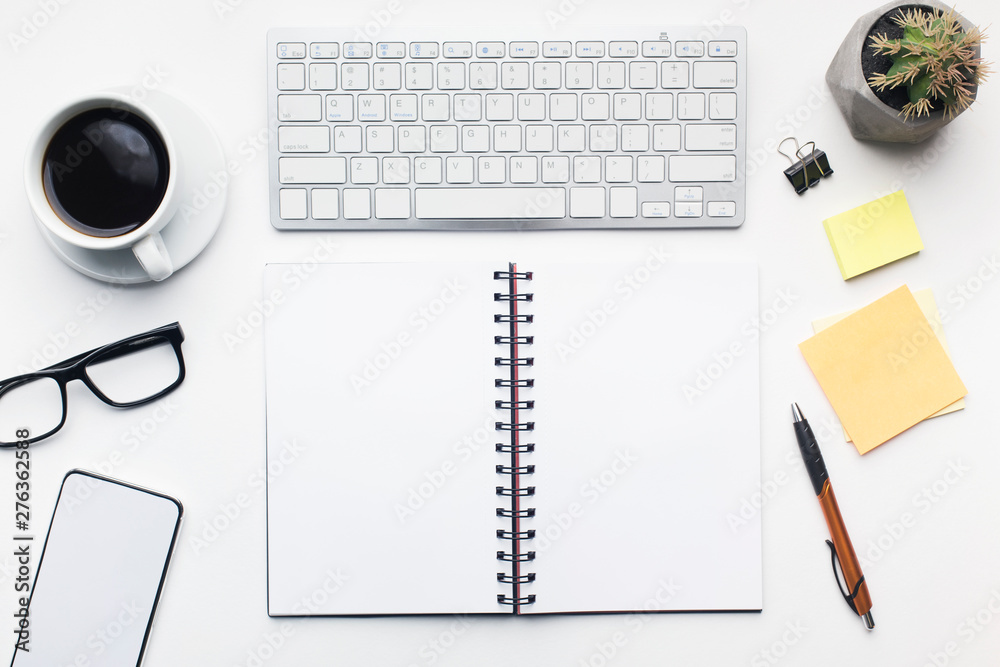 Office table with open notepad and other accessories on white Office table with open notepad and other accessories on white