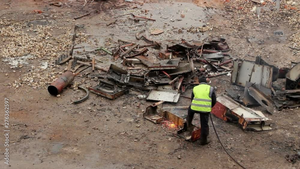 Worker is cutting manually old metal equipment using gas mixture of oxygen and acetylene, propane. Photo - JPEG video codec Worker is cutting manually old metal equipment using gas mixture of oxygen and acetylene, propane. Photo - JPEG video codec