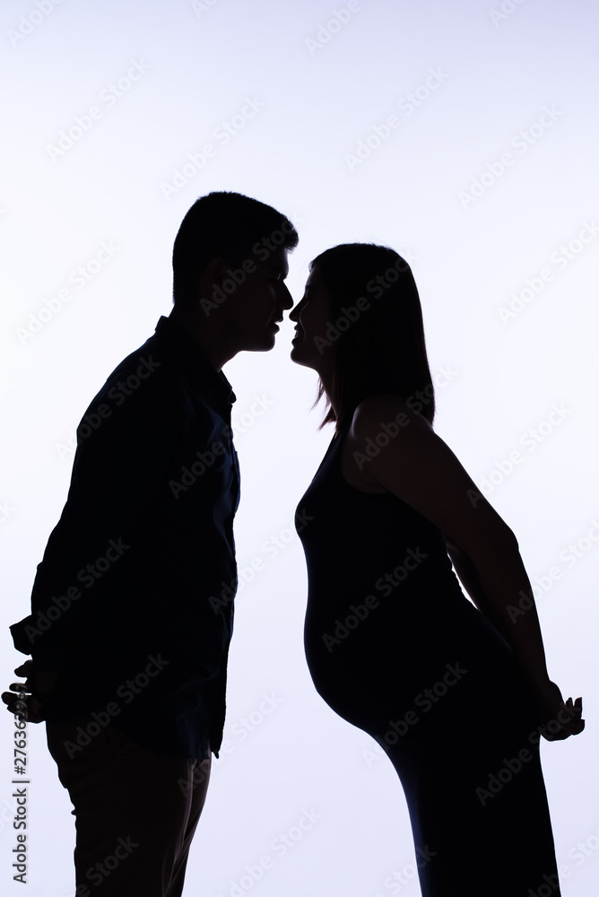 The silhouette of pregnant woman and her husband standing  face to face,with happy emotion,love and care feeling