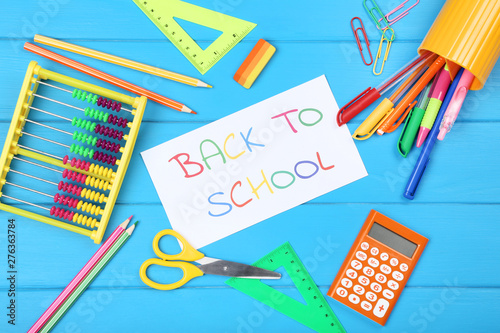 Text Back To School with stationery on blue wooden table