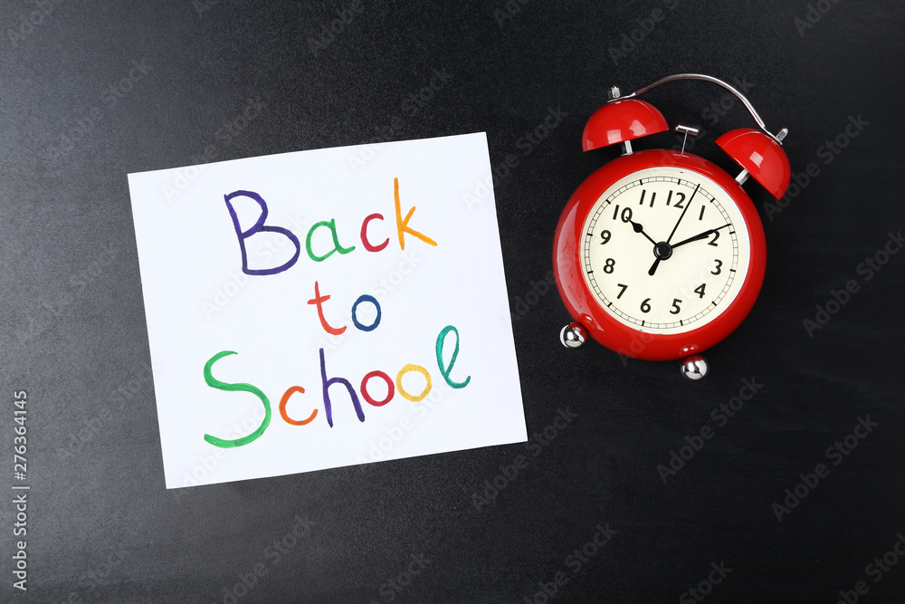 Text Back To School with red alarm clock on black background Text Back To School with red alarm clock on black background