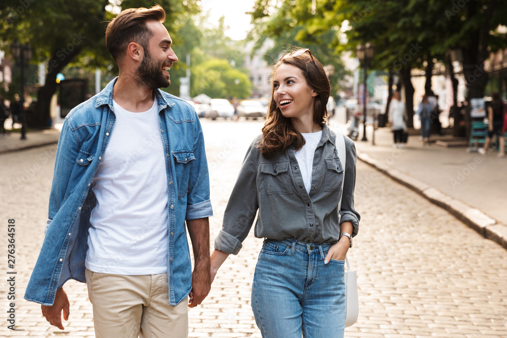 Beautiful young couple in love walking outdoors at the city street