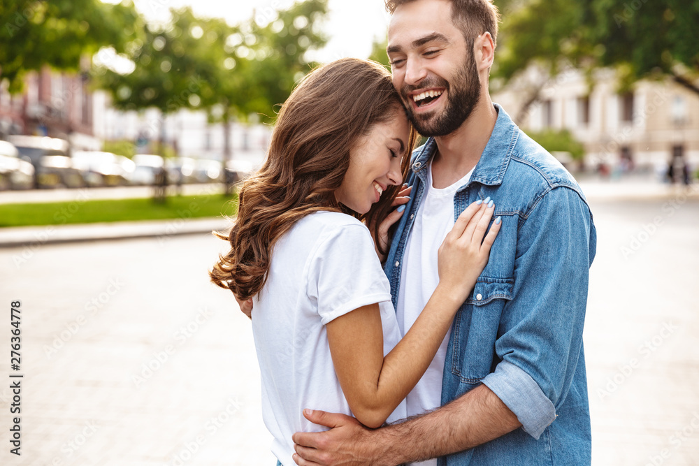 Beautiful young couple in love walking outdoors at the city street