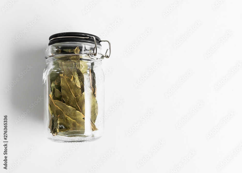 glass jar with dry bay leafs on white background glass jar with dry bay leafs on white background