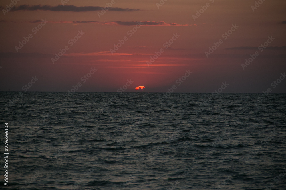 The setting sun going beyond the horizon of the Azov sea