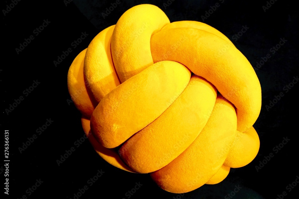 Decorative soft yellow toy on a black background.
