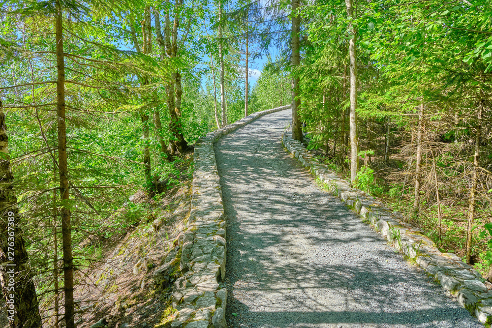 Scenic view of path near abandoned marble mine in Ruskeala national park in Karelia. Beautiful summer sunny look of road in popular touristic canyon on the North of Russian Federation Scenic view of path near abandoned marble mine in Ruskeala national park in Karelia. Beautiful summer sunny look of road in popular touristic canyon on the North of Russian Federation