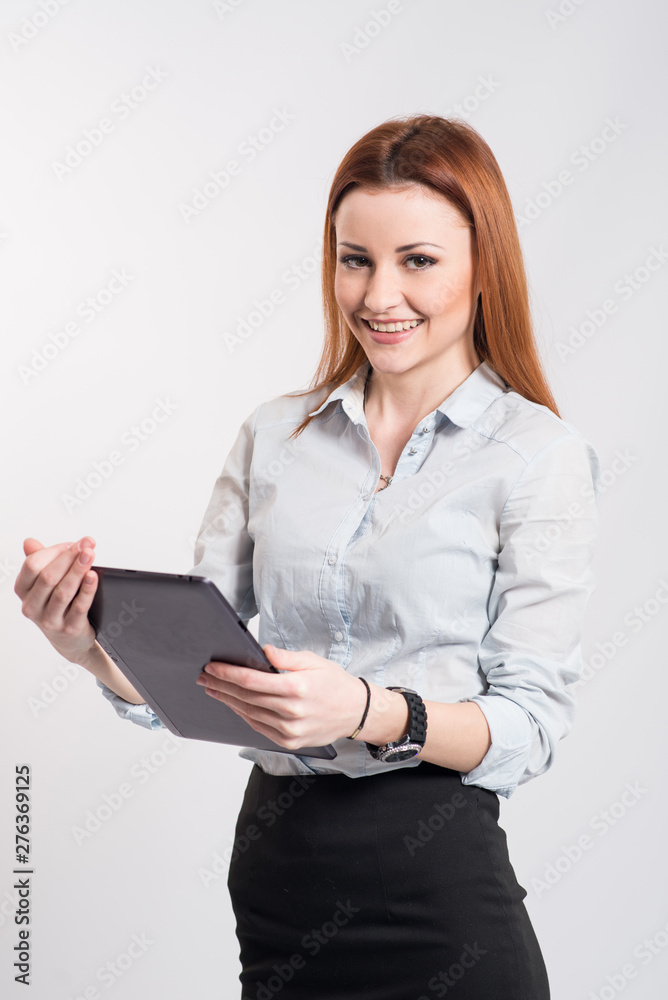 Happy smiling woman in strict clothes and glasses holding a clipboard on grey Happy smiling woman in strict clothes and glasses holding a clipboard on grey