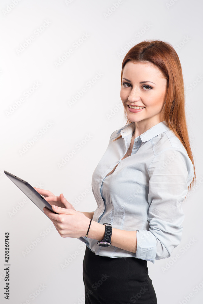 Happy smiling woman in strict clothes and glasses holding a clipboard on grey Happy smiling woman in strict clothes and glasses holding a clipboard on grey