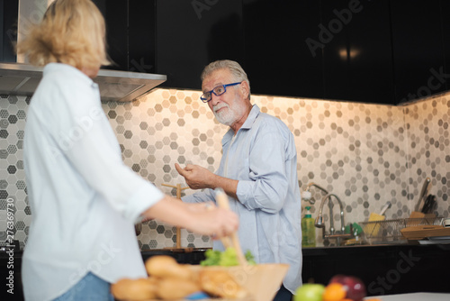 Closed up senior Caucasian couple are cooking a meal which smile and felling happy in kitchen at home. Old man and woman are cooking salad. Senior family activity at home concept.